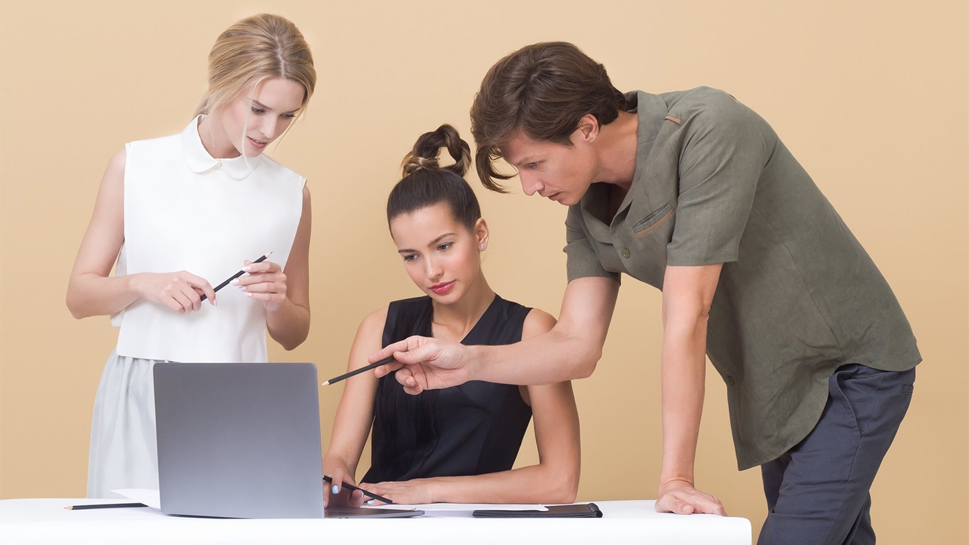 Three people looking at a computer.