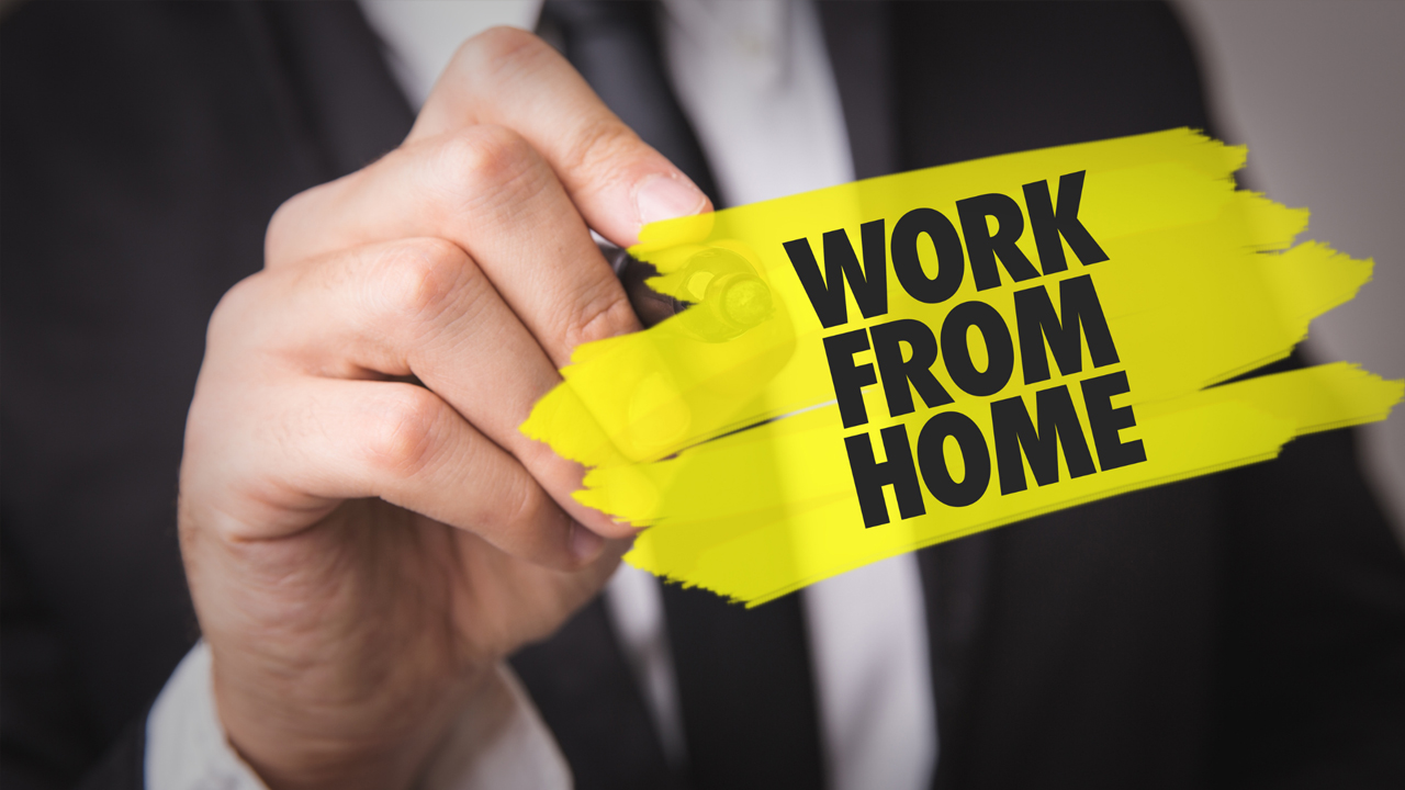 A man holding a pen next to text that says "WORK FROM HOME."